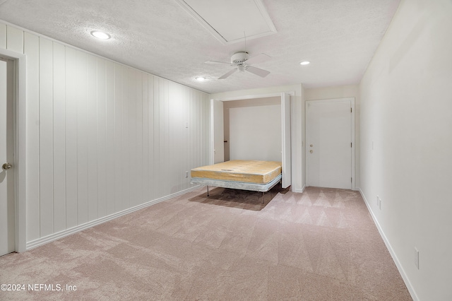 unfurnished bedroom with carpet, a textured ceiling, and ceiling fan