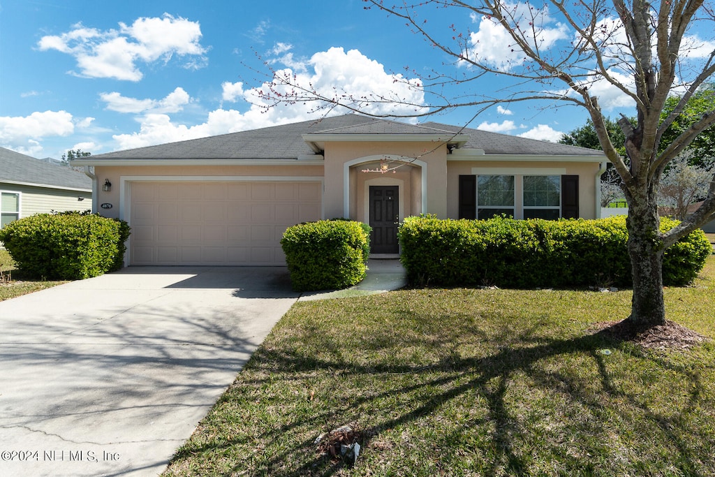 ranch-style home with a front lawn and a garage