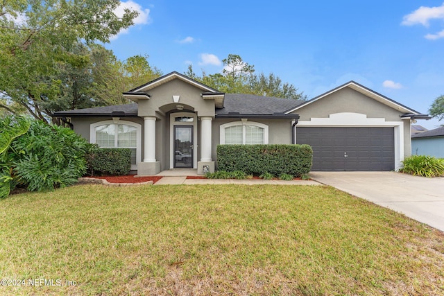 ranch-style house featuring a garage and a front lawn