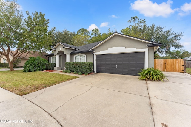 single story home with a garage and a front yard