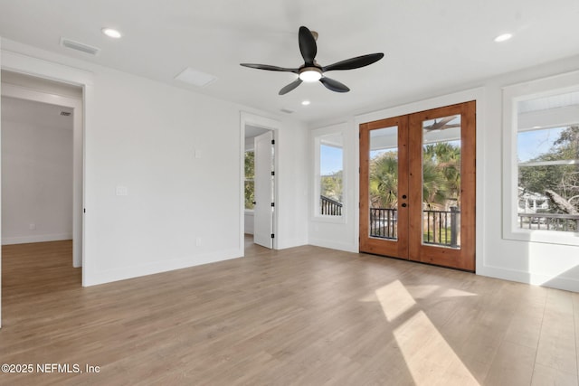 spare room featuring light wood-type flooring, visible vents, recessed lighting, french doors, and baseboards