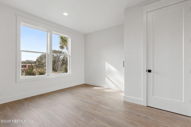 unfurnished room featuring recessed lighting, light wood-style floors, and baseboards