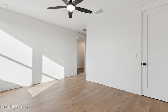 empty room featuring visible vents, baseboards, light wood-style flooring, and a ceiling fan