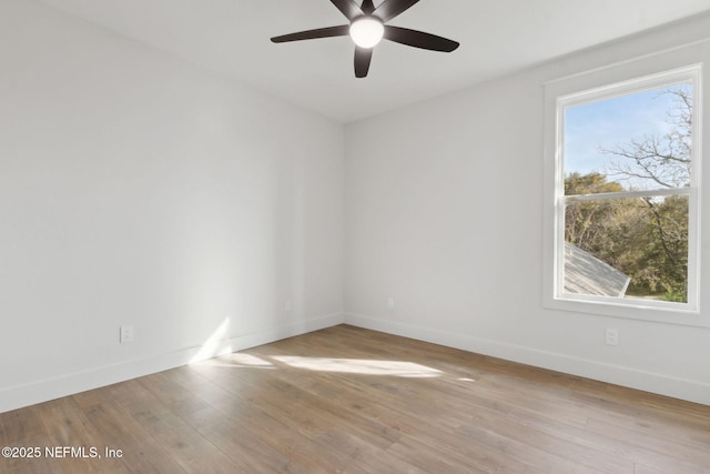 empty room featuring a ceiling fan, wood finished floors, and baseboards