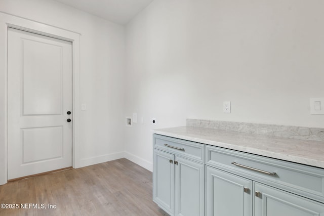 laundry area with baseboards, cabinet space, electric dryer hookup, washer hookup, and light wood-type flooring