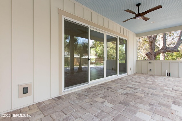 unfurnished sunroom with a ceiling fan