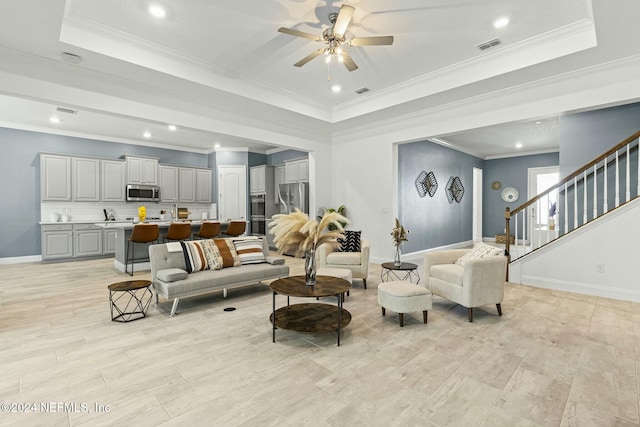 living room featuring a tray ceiling and ornamental molding