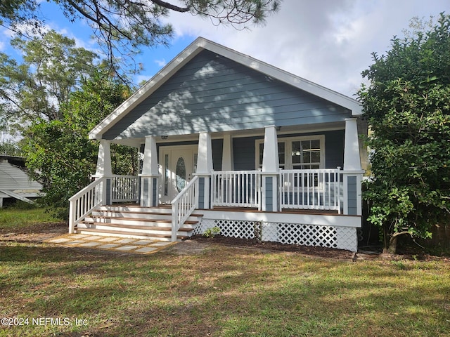 view of front of property featuring a front yard and covered porch