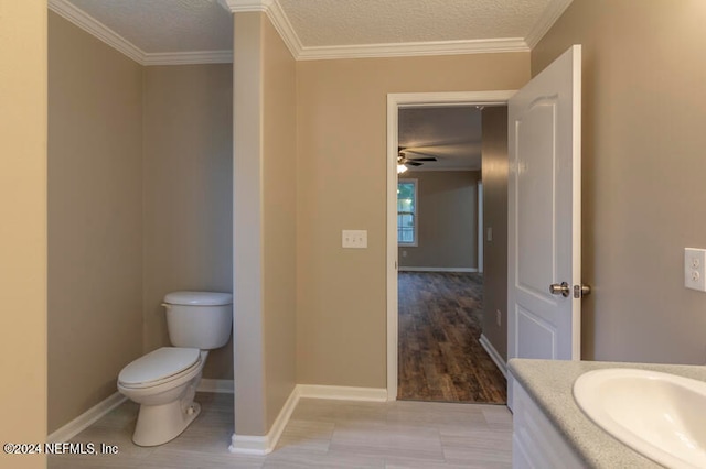 bathroom featuring crown molding, vanity, a textured ceiling, hardwood / wood-style flooring, and toilet