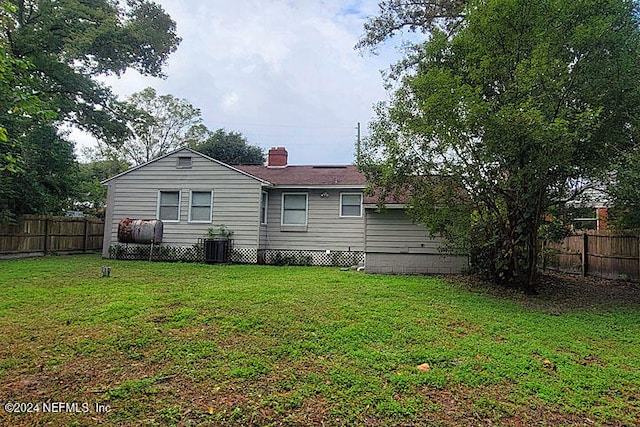 rear view of property featuring a lawn