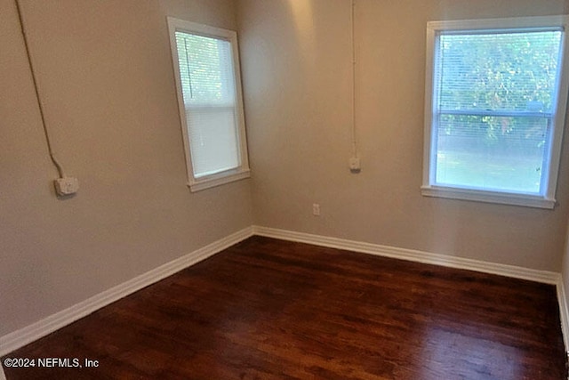 unfurnished room featuring dark wood-type flooring