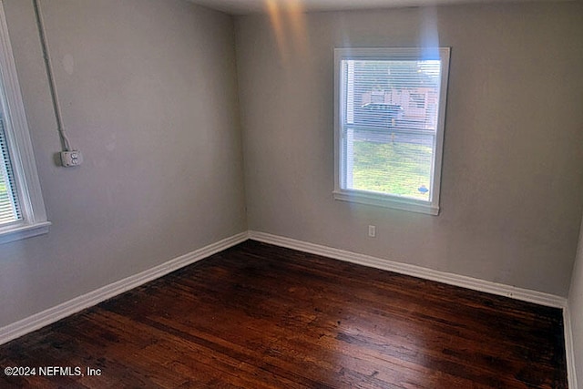 unfurnished room with dark hardwood / wood-style floors and a healthy amount of sunlight