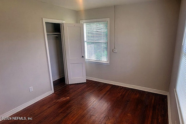 unfurnished bedroom featuring dark hardwood / wood-style floors and a closet