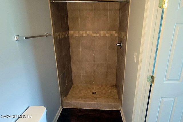 bathroom with toilet and tiled shower