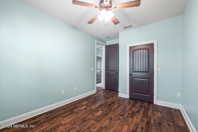 unfurnished bedroom with ceiling fan and dark hardwood / wood-style floors