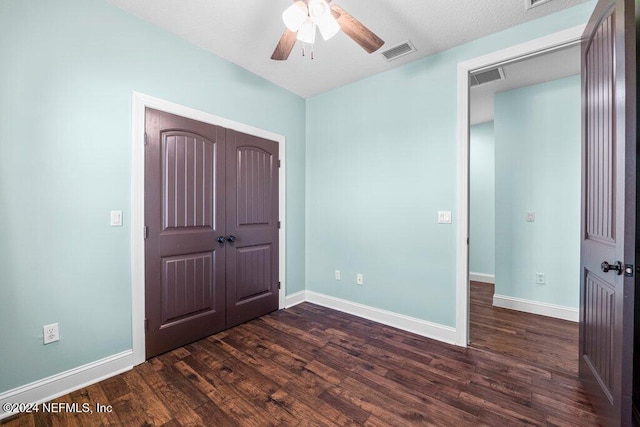 unfurnished bedroom featuring dark hardwood / wood-style flooring, a closet, a textured ceiling, and ceiling fan