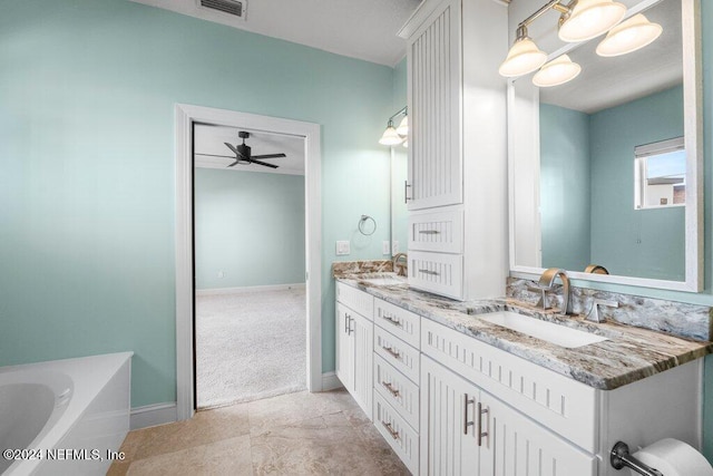 bathroom with ceiling fan, vanity, and a washtub