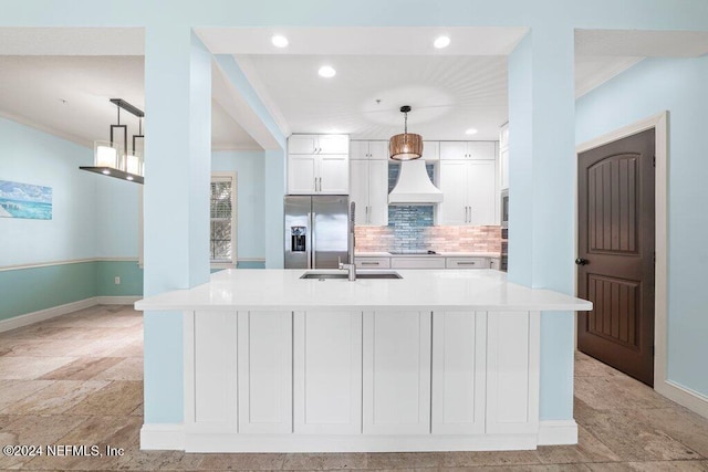 kitchen featuring stainless steel fridge, white cabinetry, hanging light fixtures, custom exhaust hood, and a spacious island