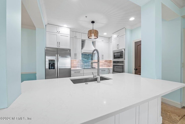 kitchen with ornamental molding, stainless steel appliances, white cabinetry, hanging light fixtures, and decorative backsplash