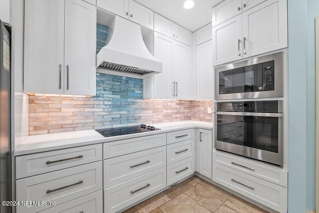 kitchen featuring custom range hood, white cabinetry, appliances with stainless steel finishes, and tasteful backsplash