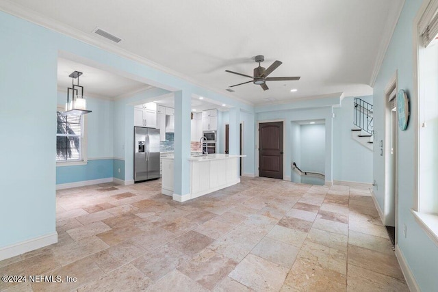 interior space featuring stainless steel appliances, white cabinetry, ornamental molding, ceiling fan, and decorative light fixtures