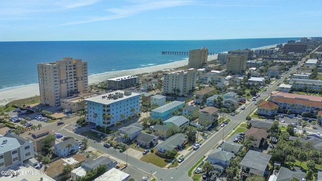 drone / aerial view featuring a city view, a view of the beach, and a water view