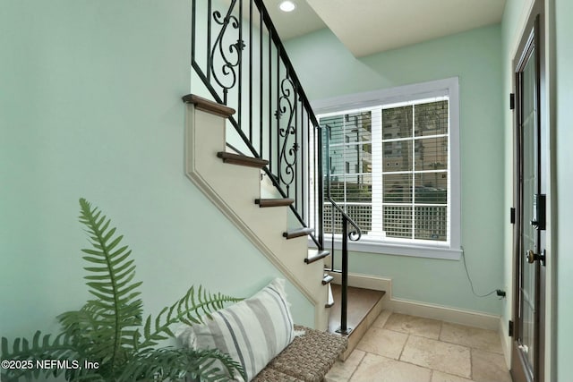 stairs featuring stone tile floors, recessed lighting, and baseboards