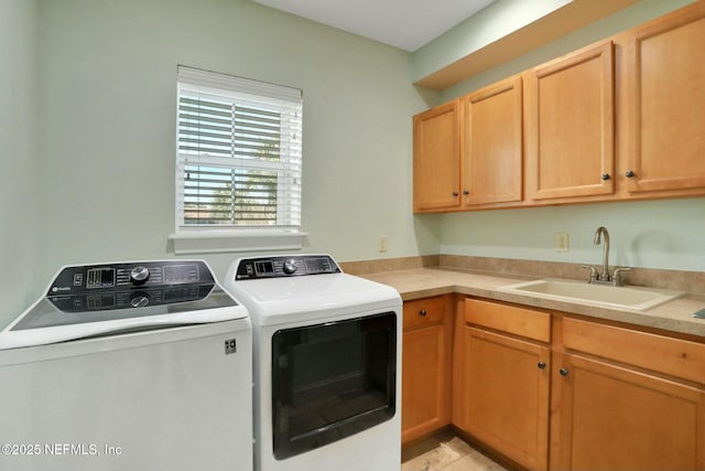 clothes washing area with cabinet space, separate washer and dryer, and a sink