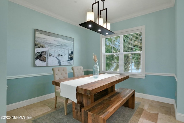 dining room with stone finish flooring, baseboards, and ornamental molding