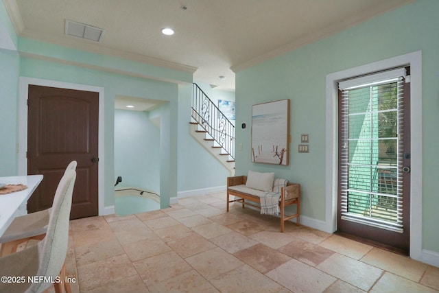 entrance foyer featuring visible vents, crown molding, baseboards, stairway, and stone tile floors