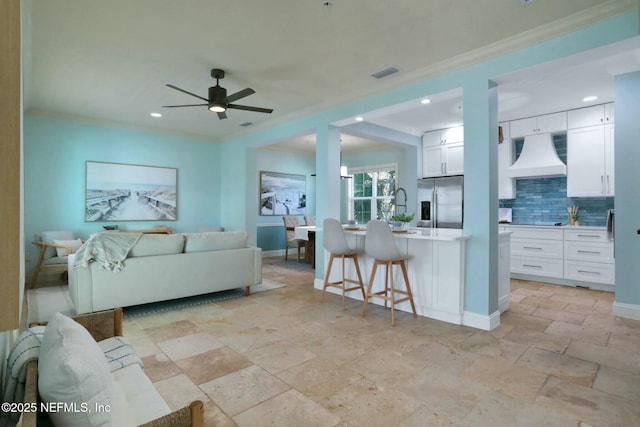 living room featuring visible vents, a ceiling fan, stone finish flooring, recessed lighting, and baseboards