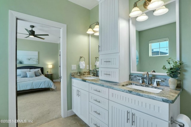 ensuite bathroom with a sink, ensuite bath, double vanity, and ceiling fan