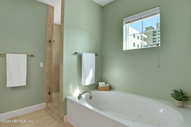 bathroom featuring a tub with jets, a stall shower, and baseboards