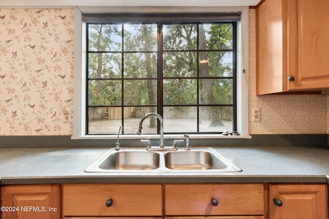 300 Raintree Trl, Saint Augustine, FL 32086 - kitchen with a sink, wallpapered walls, dark countertops, and light brown cabinetry