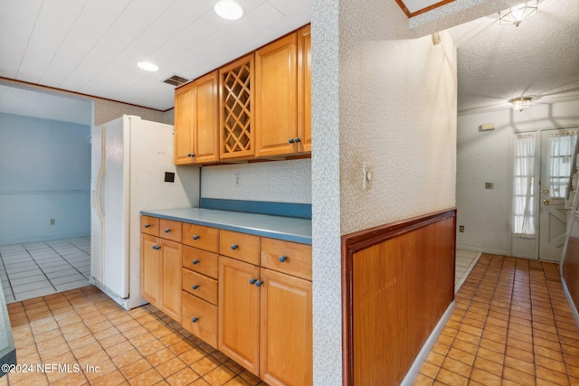 kitchen featuring light tile patterned floors, white fridge with ice dispenser, and backsplash