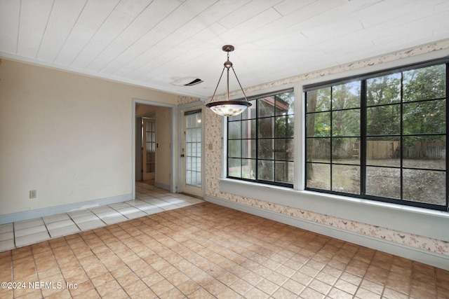 unfurnished dining area featuring ornamental molding, an inviting chandelier, and a healthy amount of sunlight