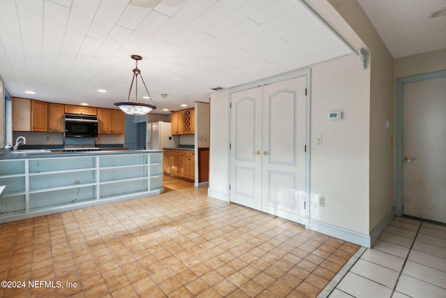 kitchen featuring white refrigerator with ice dispenser, sink, and hanging light fixtures