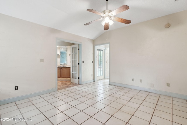 spare room with sink, ceiling fan, light tile patterned floors, and vaulted ceiling