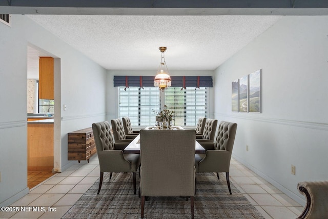 tiled dining space featuring a textured ceiling