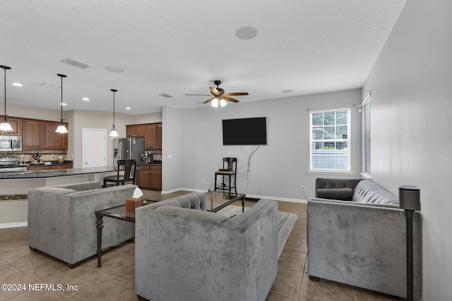 living room featuring tile patterned flooring, recessed lighting, a ceiling fan, visible vents, and baseboards