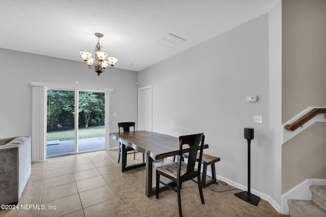 dining area with stairs, light tile patterned floors, a textured ceiling, and an inviting chandelier