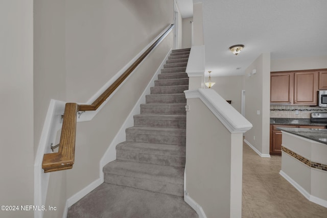 staircase featuring baseboards and tile patterned floors