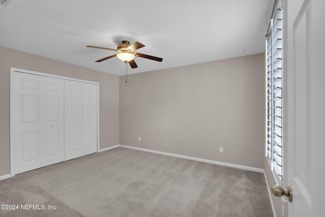 unfurnished bedroom with a textured ceiling, a closet, carpet flooring, and baseboards