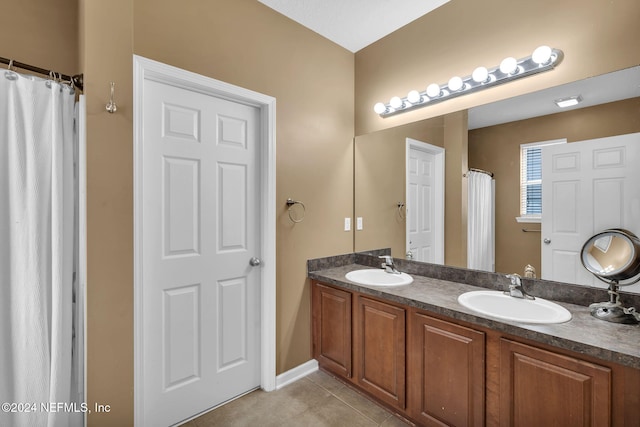 bathroom featuring double vanity, tile patterned flooring, and a sink