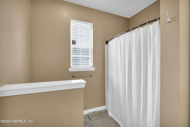 full bath with a shower with curtain, tile patterned flooring, and baseboards