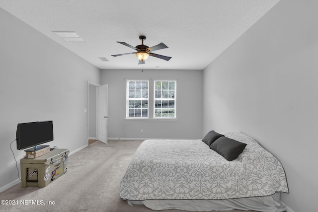 bedroom with a textured ceiling, ceiling fan, carpet flooring, visible vents, and baseboards