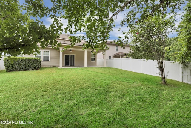 view of yard featuring ceiling fan and a fenced backyard