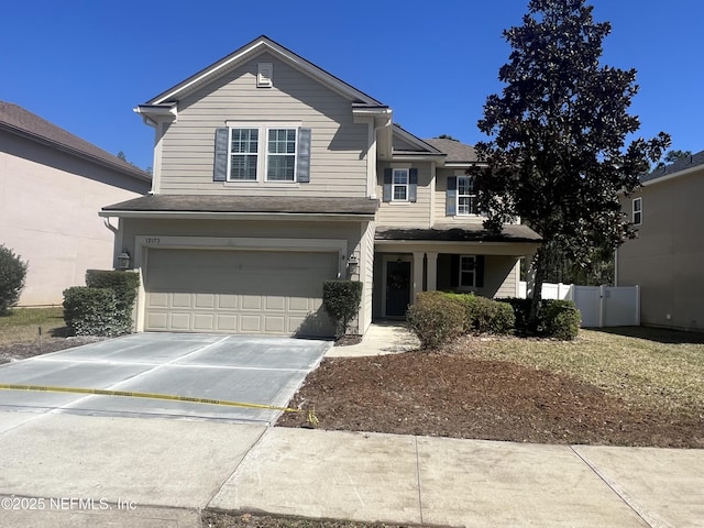 traditional-style house with concrete driveway, an attached garage, and fence