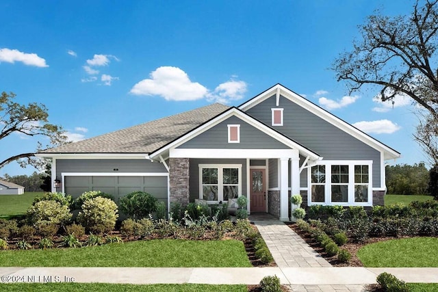 view of front of property with a front lawn, a garage, and covered porch