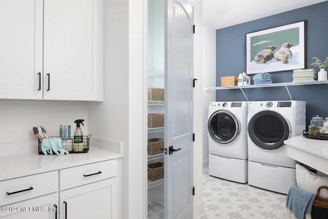 laundry area featuring washing machine and dryer and cabinets